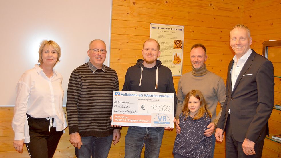 Das Foto zeigt Carmen Vietor (links) und Uwe Brechtezende (rechts) als Vertreter der Volksbank Westrhauderfehn sowie (von links) Böde Busboom (Vorsitzender Imkerverein Rhauderfehn und Umgebung) sowie Timo Buskohl und Marcus Hinrichs mit Tochter Melina (alle Imkerverein) bei der Scheckübergabe. Foto: Weers