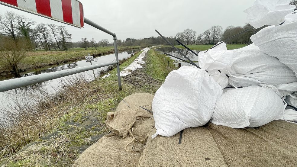 Hier an der Roten Riede in Langholt kämpften vor einer Woche noch die Feuerwehren gegen das Hochwasser. Der Pegel ist deutlich niedriger, aber die Sandsäcke liegen noch auf dem aufgeweichten Deich. Foto: Hellmers