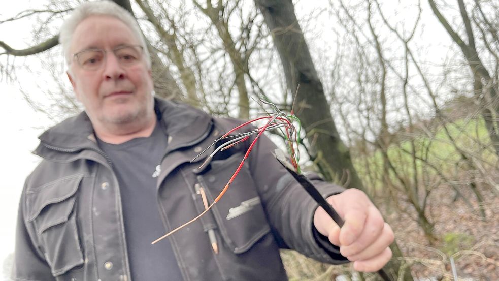 Wilfried Herrmann aus Ostrhauderfehn mit dem losen Kabel-Ende, das im Graben gelandet war. Foto: Janßen