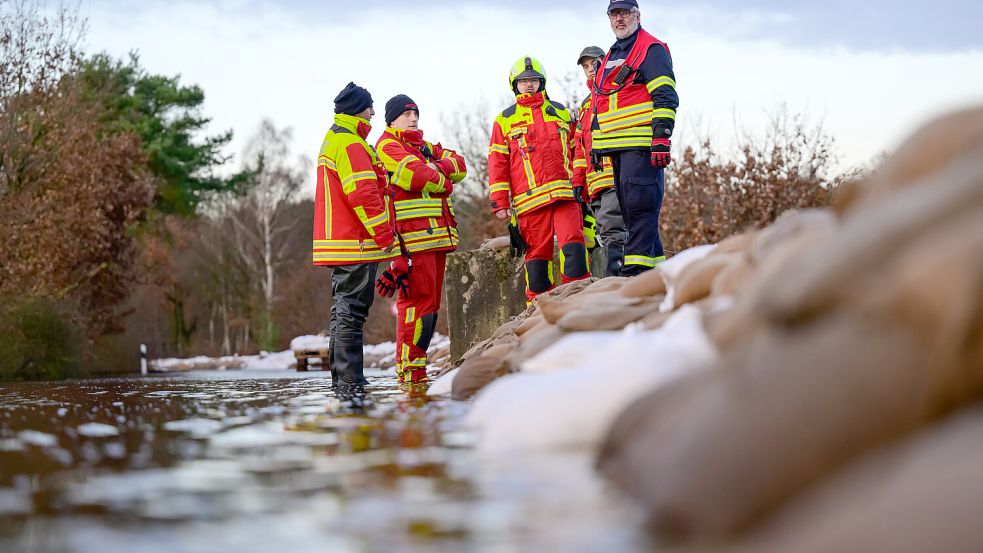 Lagebesprechung am Schutzwall aus Sandsäcken: Ehrenamtliche Helfer der Feuerwehr beim Hochwassereinsatz. Foto: dpa/Philipp Schulze