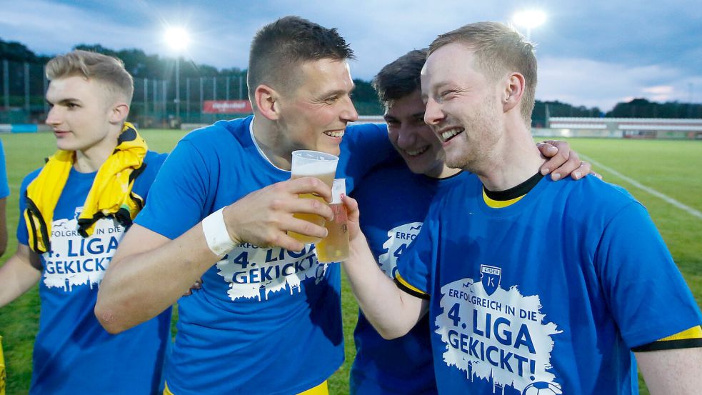 2022 setzte sich Kickers Emden in der Aufstiegsrunde zur Regionalliga durch. Darauf stießen Kapitän Bastian Dassel (links) und Matthias Goosmann an. Foto: Doden/Emden