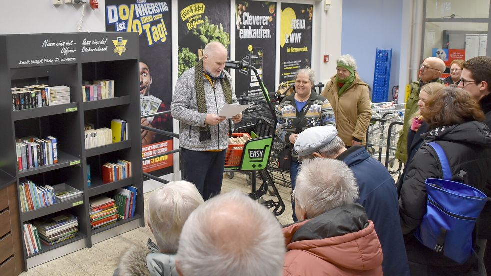 Detlef M. Plaisier (mit den Zetteln in der Hand) und seine Ehefrau Sandra Gräfenstein-Plaisier (rechts daneben) konnten zur Eröffnung des Bücherschrankes (links im Bild) zahlreiche Gäste begrü´ßen. Foto: Ammermann