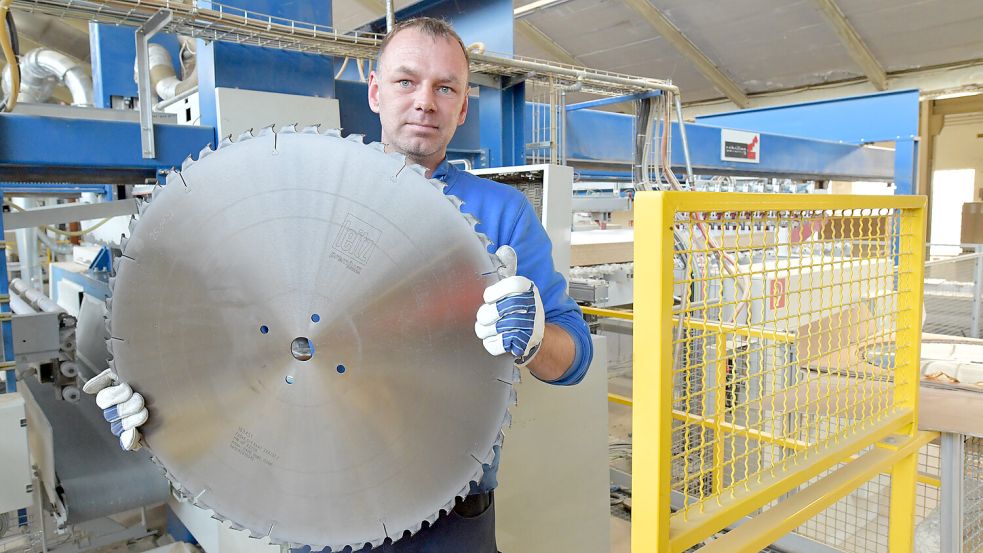 Mitarbeiter Sven Vietor zeigt ein großes Sägeblatt, das gerade gewechselt werden muss. Foto: Ortgies