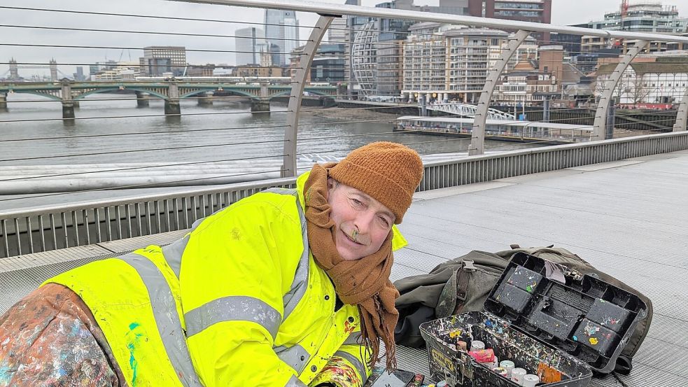 In seinem leuchtend orangen, mit Farbschichten überzogenen Industrieoverall mitten auf der Brücke oder auf Gehwegen der geschäftigen City wird der Künstler selbst zur Provokation. Foto: Susanne Ebner