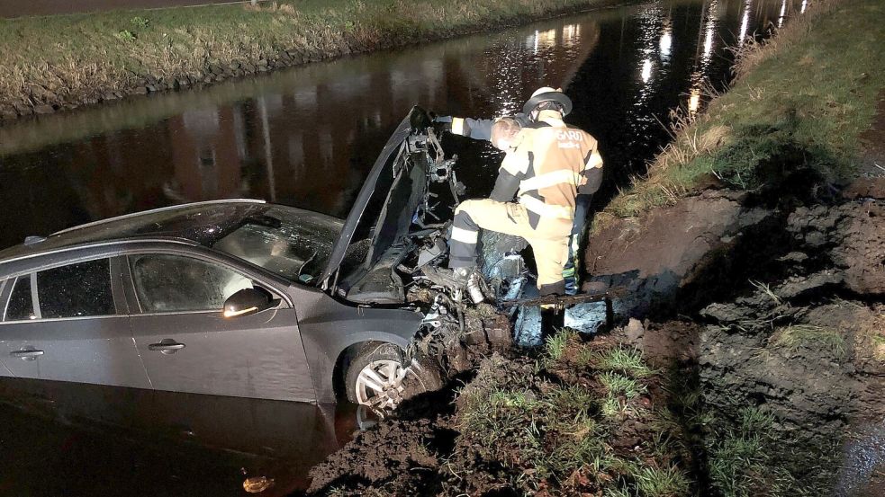 Der Wagen schlug auf der anderen Kanalseite in die Böschung ein. Feuerwehrleute klemmten die Batterie ab. Foto: Ammermann