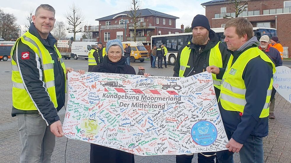 Geredet hat Gitta Connemann in Rhauderfehn zwar nicht, aber sie nahm ein Plakat von den Organisatoren der Mittelstand-Demos aus Moormerland in Empfang. Übergeben hatten dies (von links) Matthias Brakebusch, Christian Janßen und Dirk Busker. Foto: privat