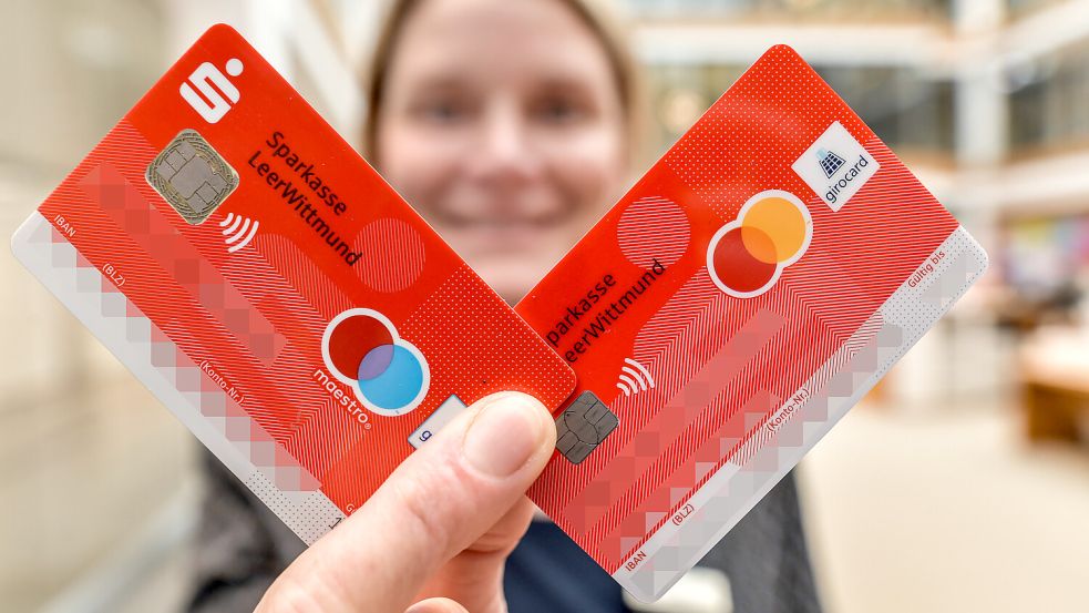 Inga Coordes von der Sparkasse Leer-Wittmund hält eine alte (links) und eine neue Girocard ihres Kreditinstituts. Die alte verfügt noch über die eingestellte Maestro-Funktion. Die neue hat neben der Girocard auch eine Debit-Mastercard. Foto: Ortgies