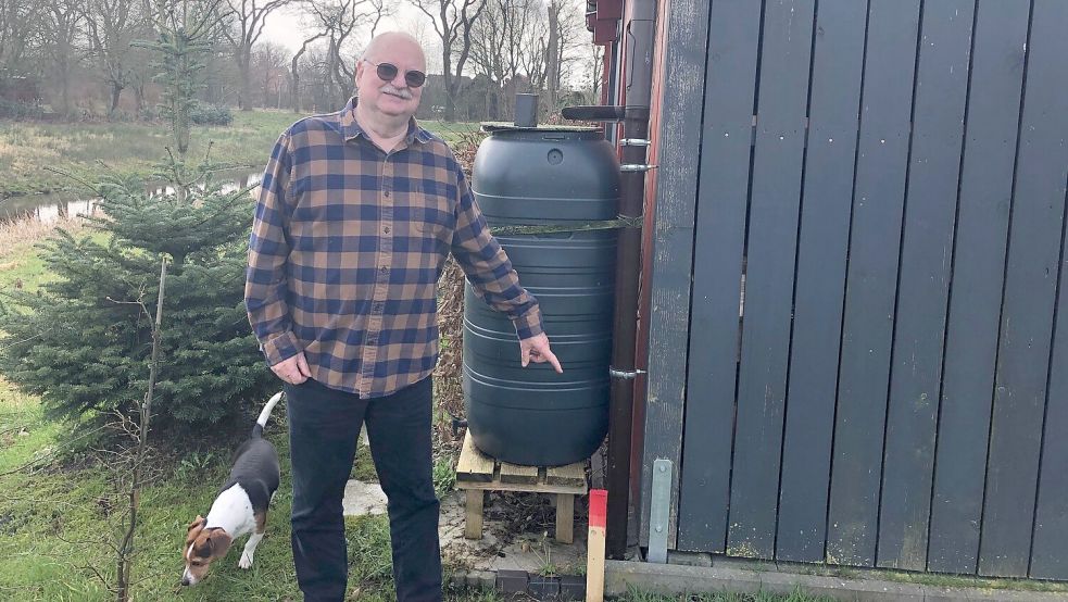 Walter M. Schmid zeigt auf einen Pflock in der Erde. Rechts ist sein Grundstück, links die Fläche der Gemeinde Saterland. Alles was Schmid darauf gestellt oder gepflanzt hat, lässt er nun entfernen. Foto: Kruse