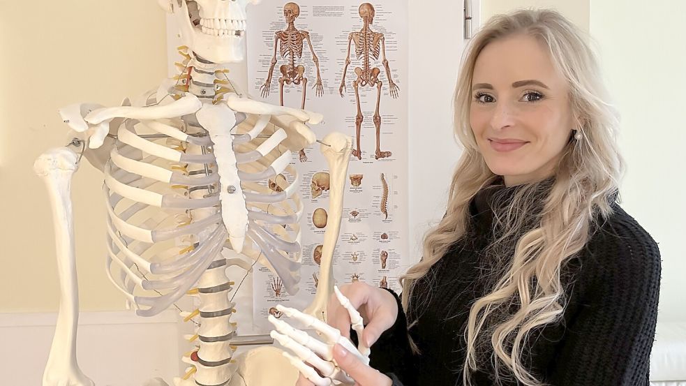 Die angehende Landärztin Annika Bölke steht in ihrem Wohnzimmer an einem Modell eines Skeletts. Hin und wieder lernt sie auf dem Fußboden im Kinderzimmer. Foto: Lars Laue