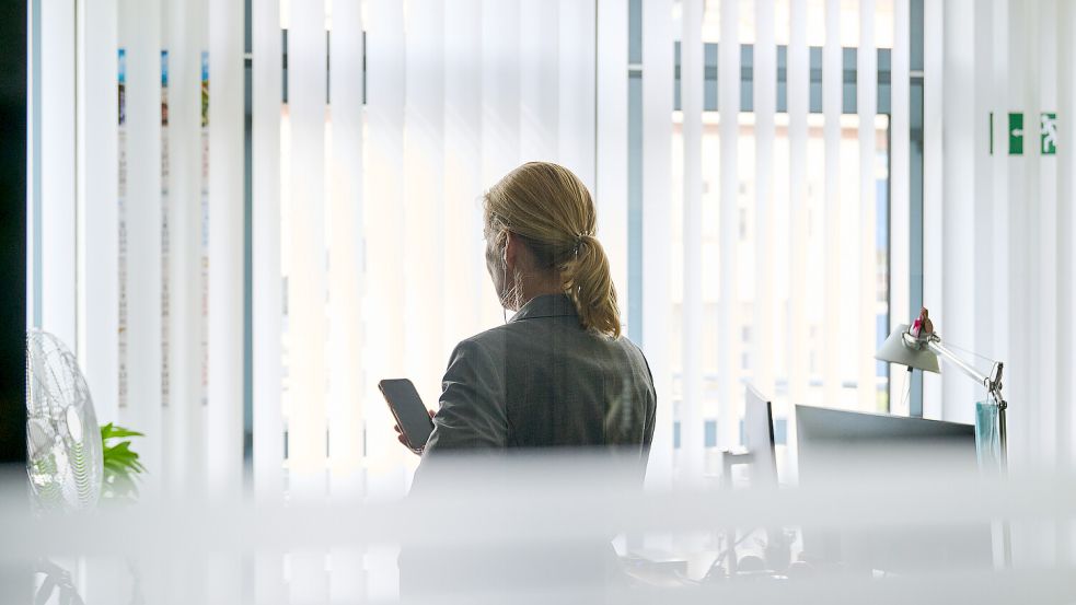 Eine Frau steht in einem Bürozimmer und telefoniert. Über die Bezahlung der Büroleiterin von Ministerpräsident Stephan Weil (SPD) ist in Niedersachsen eine Debatte entbrannt. Foto: Annette Riedl/dpa