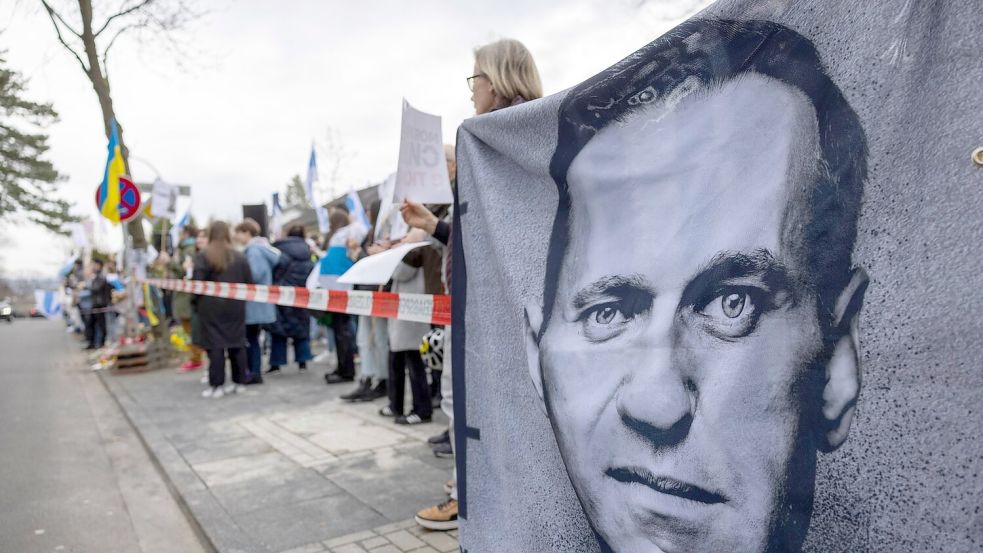 Demonstranten halten vor dem russischen Generalkonsulat in Bonn ein Banner mit dem Porträt des gestorbenen Alexej Nawalny. Foto: Thomas Banneyer/dpa