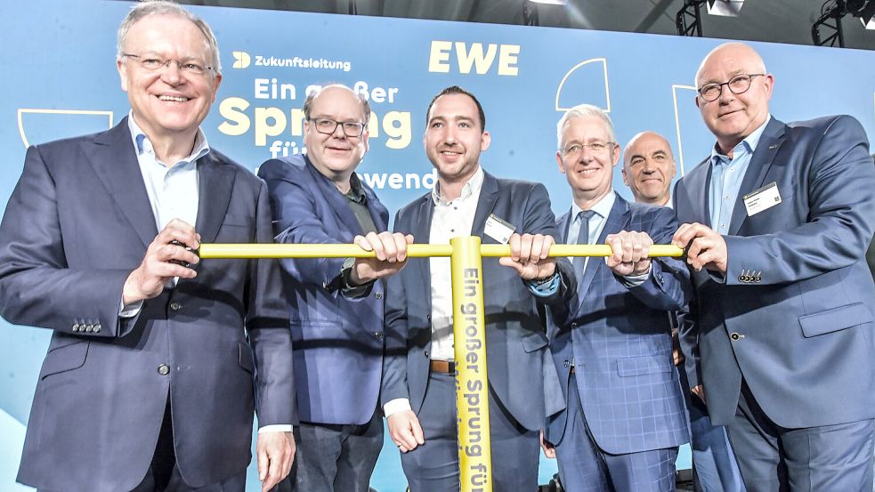 Niedersachsens Ministerpräsident Stephan Weil (SPD) (von links), Umweltminister Christian Meyer (Grüne), SPD-Landtagsabgeordneter Nico Bloem, Landrat Matthias Groote (SPD), Vorstandsvorsitzender der EWE Stefan Dohler (hinten) und Jemgums Bürgermeister Hans-Peter Heikens (parteilos) drehen den „Schieber-Schlüssel für die Energiewende“. Foto: Ortgies
