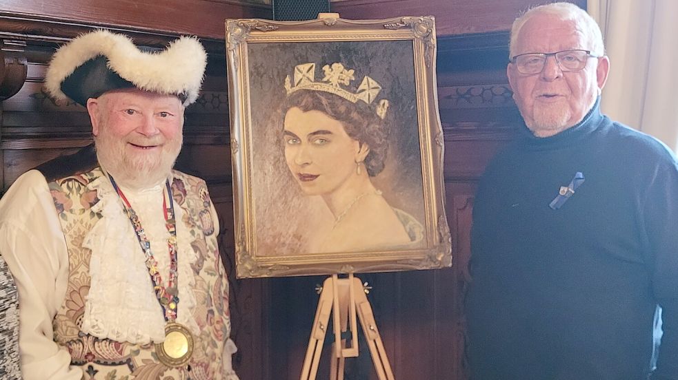 Die beiden Ehrenherolde der Stadt Leer: Trevor Heeks und Bodo Wolters neben einem Bild von Queen Elizabeth II. Foto: Wolters