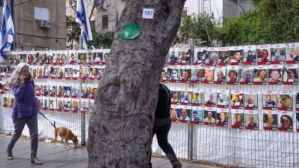 An einem Zaun in einem Vorort von Tel Aviv sind Fotos von Israelis angebracht sind, die im Gazastreifen von der islamistischen Hamas als Geiseln festgehalten werden. Foto: Oded Balilty/AP/dpa