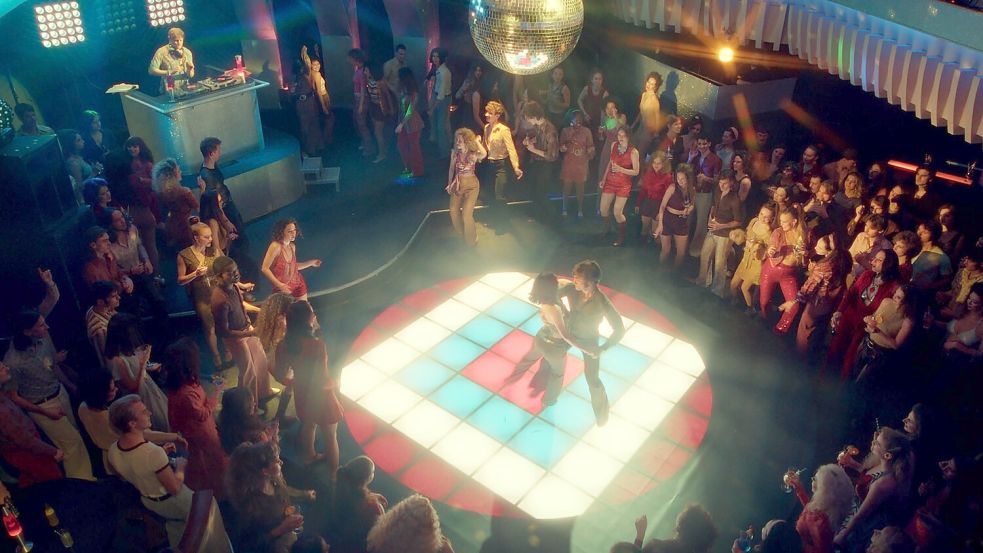 Erinnert an „Saturday Night Fever“ – die Tanzfläche in der Serie „Disko 76“. In der Szene tanzen Elisabeth (Emma Nova) und Robert (Jannik Schümann), um sich für einen Tanzwettbewerb zu qualifizieren. Foto: RTL