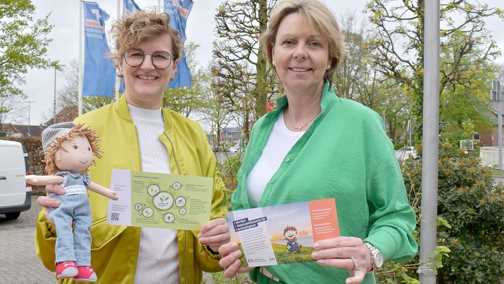 Daniela Abheiden (links) und Carmen Vietor von der Volksbank Westrhauderfehn freuen sich auf die Bewerbungen für den Ideen-Wettbewerb. Mit dabei ist auch Maskottchen Fin. Foto: Zein