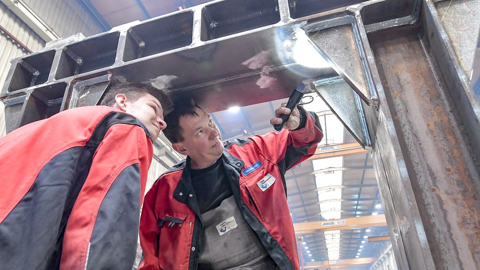 Alexander Klut (rechts) und Eike Frerichs, Mitarbeiter der Qualitätssicherung, prüfen ein großes Stahlteil. Foto: Ortgies