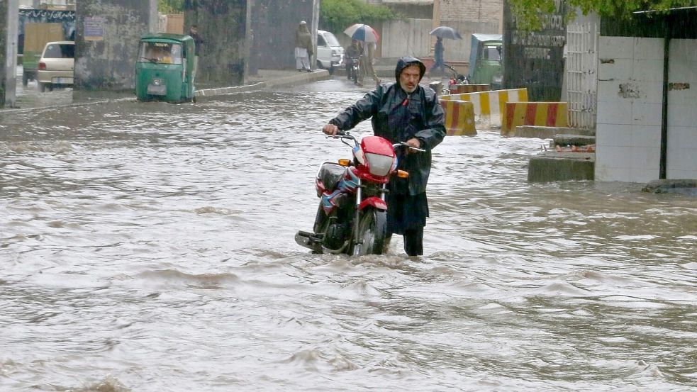 Starke Regenfälle haben die Straßen im pakistanischen Peschawar überschwemmt. In Pakistan sind bei für diese Jahreszeit ungewöhnlich starken Regenfällen mehrere Menschen ums Leben gekommen. Foto: Muhammad Sajjad/AP/dpa