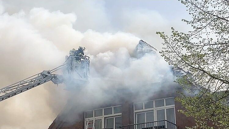 Von der Drehleiter aus bekämpft die Feuerwehr die Flammen. Foto: Ahrends