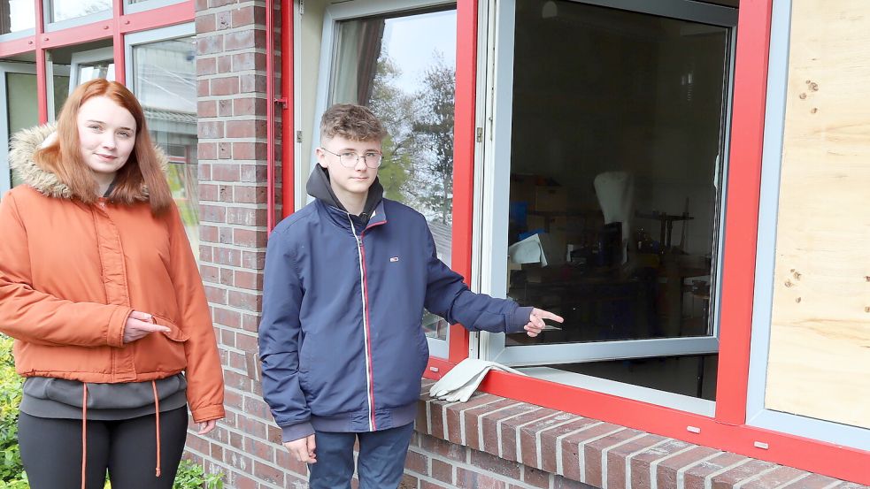 Hier im Werkraum der Grundschule Sonnentau entdeckten (von links) Michelle und Dominik Hilbrands das Feuer. Die von der Feuerwehr eingeschlagene Scheibe wurde vom Schulträger provisorisch durch eine Platte ersetzt. Fotos: Passmann