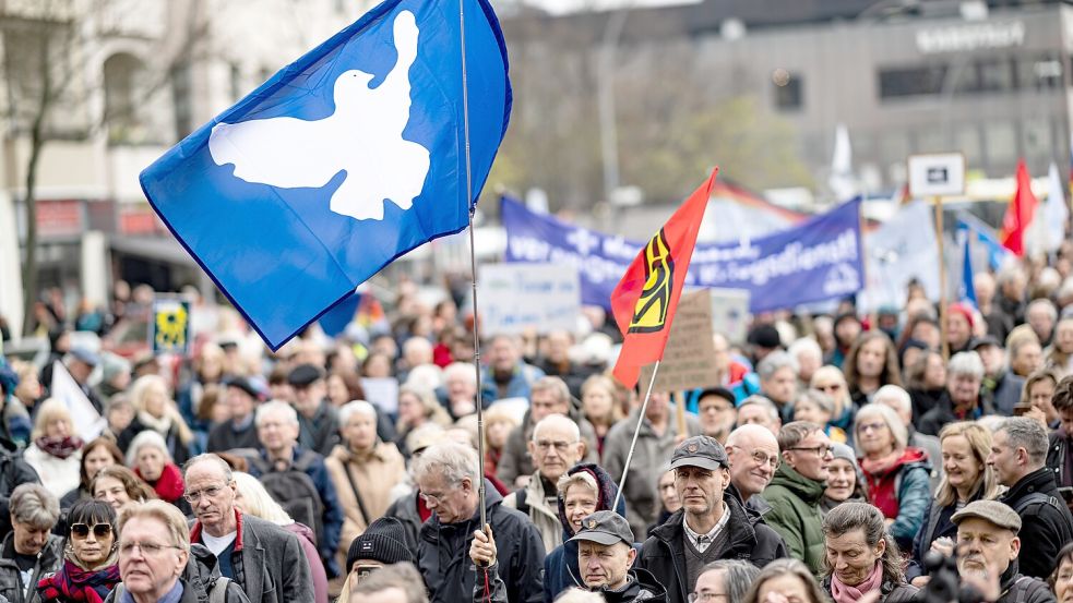 Frieden wollen alle. Aber wie kommt man ihm wirklich näher? Unter einer Fahne mit der Friedenstaube demonstrieren Menschen 2023 beim Ostermarsch in Berlin-Wedding. Foto: picture-alliance/dpa