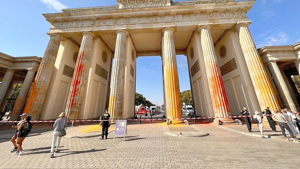 Mitglieder der Klimagruppe Letzte Generation sprühten das Brandenburger Tor im vergangenen September mit oranger Farbe an. Foto: Paul Zinken/dpa