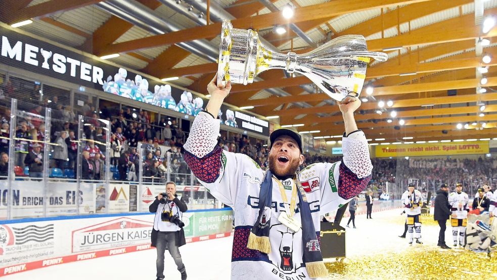 Berlins Yannick Veilleux jubelt nach dem Gewinn der deutschen Eishockey-Meisterschaft mit dem Pokal. Foto: Carmen Jaspersen/dpa