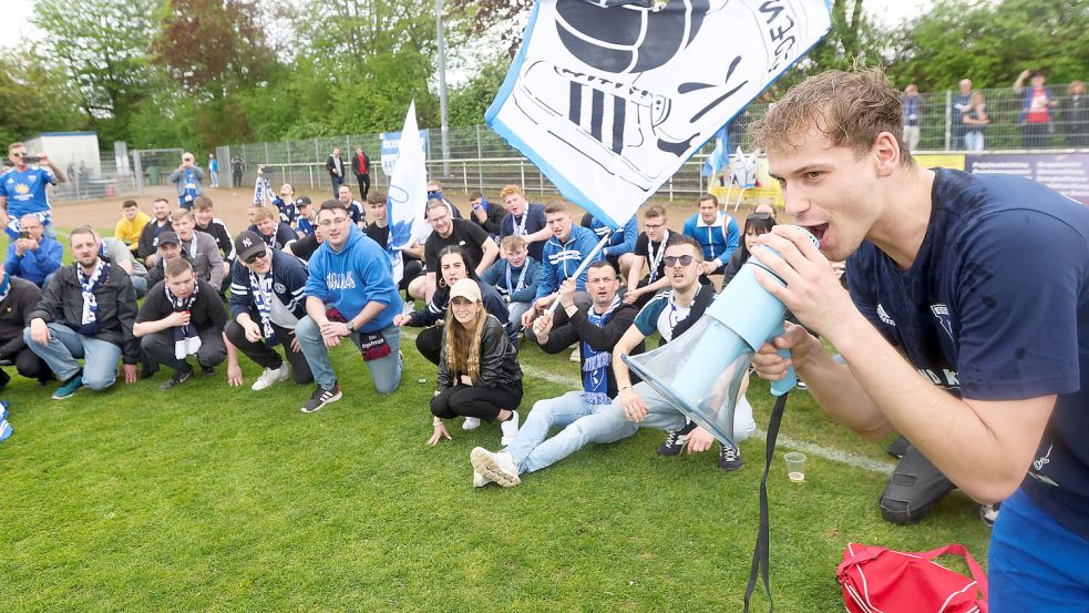 David Schiller stimmte eine Humba an. Auch die Emder Fans, die mit auf den Rasen durften, waren dabei. Foto: Doden