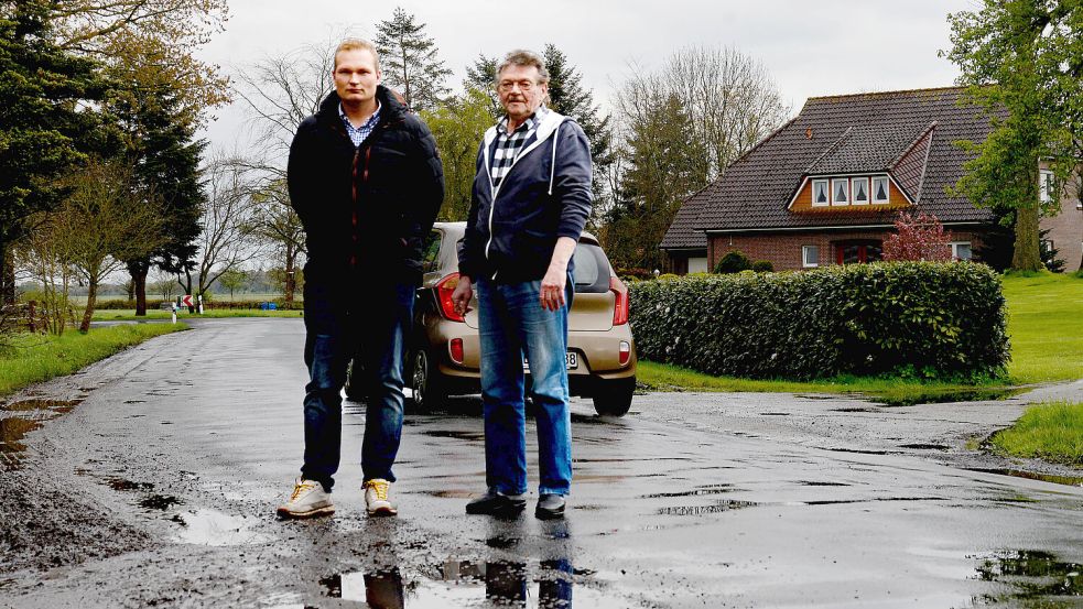 Über aufgeweichte Seitenstreifen, Schlaglöcher und große Pfützen in der Hasselter Straße ärgern sich die Anwohner Timo Schwarte (links) und Karl Tuitjer. Foto: Lüppen