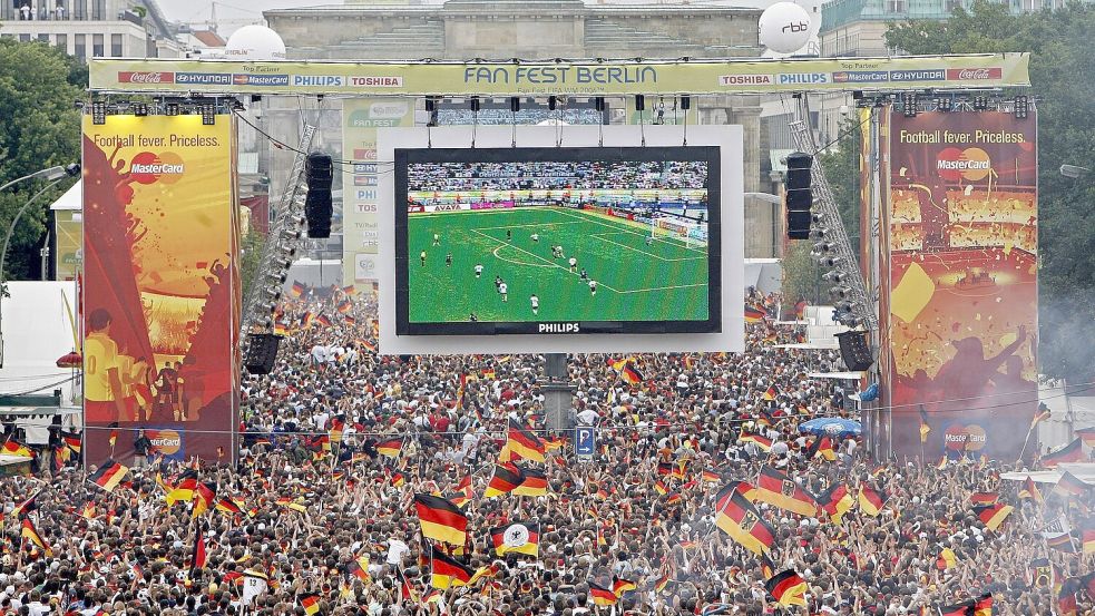 Tausende Zuschauer verfolgen 2006 auf der Fanmeile am Brandenburger Tor in Berlin das WM-Fußballspiel zwischen Deutschland und Argentinien. Foto: Marcel Mettelsiefen/dpa/Archivbild