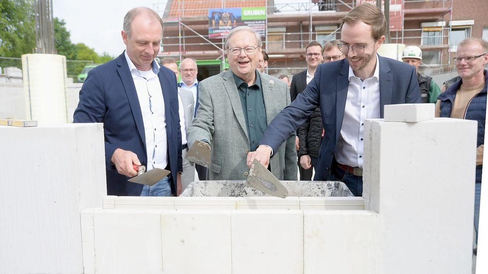 Den Grundstein füllten die Real-Geschäftsführer Michael Otto (von links) und Dieter Baumann sowie Bürgermeister Hendrik Schulz als erste mit Mörtel. Foto: Lüppen