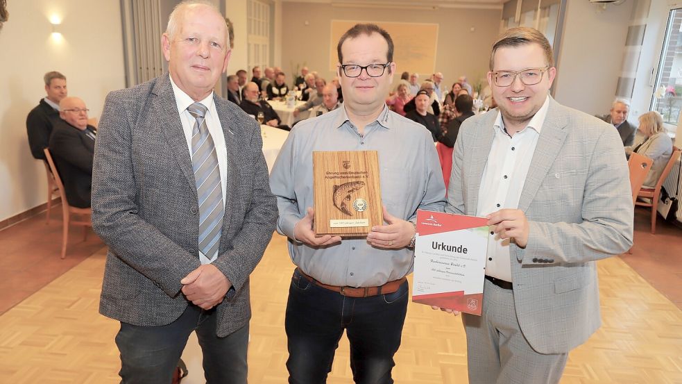 Zum 100-jährigen Jubiläum gratulierten der Präsident des Landesfischerverbandes, Heinz Gräßner (links), und Bürgermeister Nils Anhuth (rechts). Sie überreichten Geschenke an den Vorsitzenden Eilert Büscherhoff. Foto: Passmann