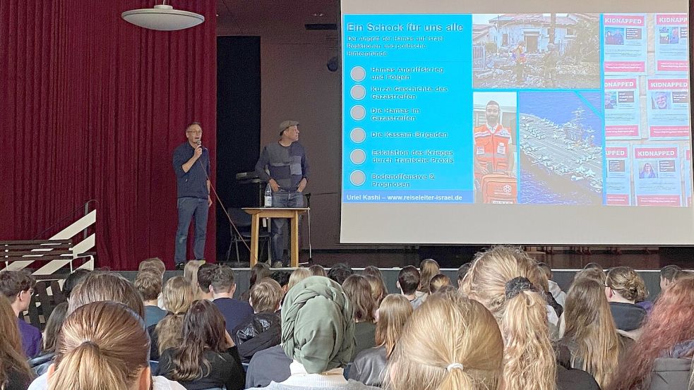 Der stellvertretende Schulleiter des Albrecht-Weinberg-Gymnasiums Rhauderfehn, Axel Bunjes (hinten links), begrüßte den in Israel lebenden Reiseleiter Uriel Kashi (hinten rechts) und die Schüler zum Vortrag. Kashi referierte über den Angriff der Hamas auf Israel, über die Reaktionen und die politischen Hintergründe. Foto: Marius Ammermann