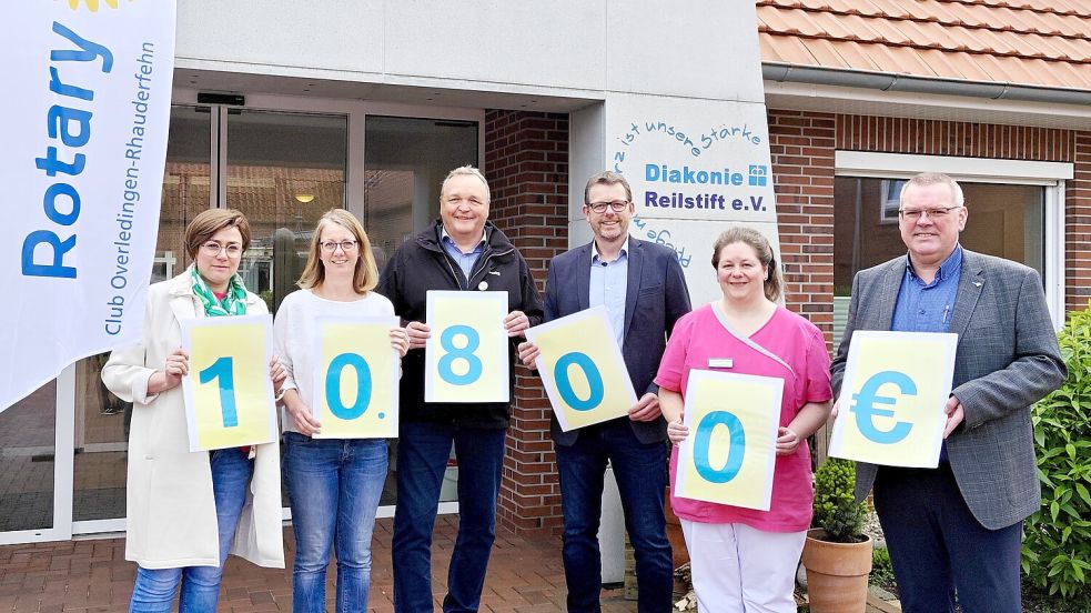 Symbolisch halten Silke Pahl von Pahl Pflege mit Hauptsitz in Flachsmeer, Maike Lammers von Pahl Pflege, Thomas Weichers vom Rotary-Club Overledingen-Rhauderfehn, Rotary-Präsident Andreas Jansen, Tanja de Freese vom Rhauderfehner Reilstift und Reilstift-Vorsitzender Rainer Helmers die Zettel mit der Zahl 10.800 Euro in den Händen. Den Betrag spendet Rotary. Foto: Rotary