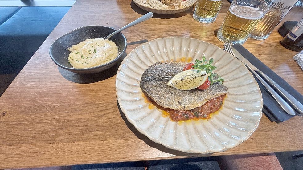 Der Hauptgang: Wolfsbarsch mit einer Puttanesca-Soße und Kartoffelpüree. Foto: Bothe