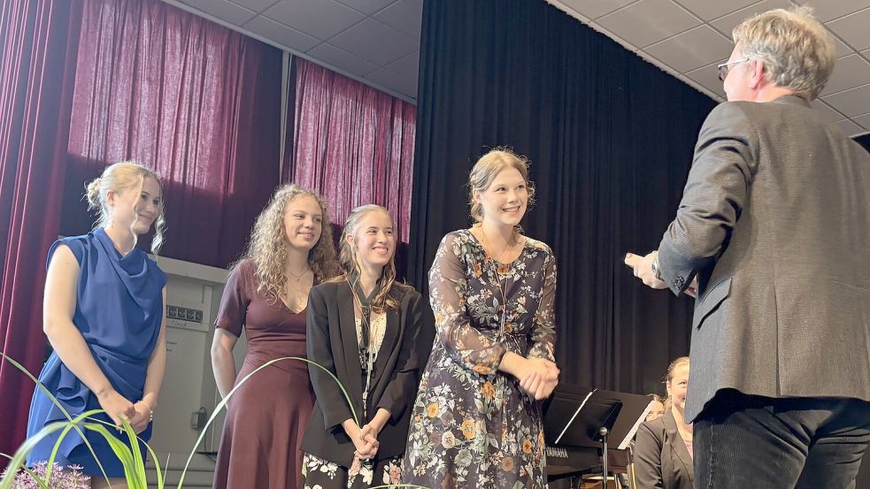 Musiklehrer Björn Andresen verabschiedete drei Mitglieder der Bigband: Pia Seemann, Viktoria Kwint, Lara Frey und Majuka Luitjens. Foto: Janßen