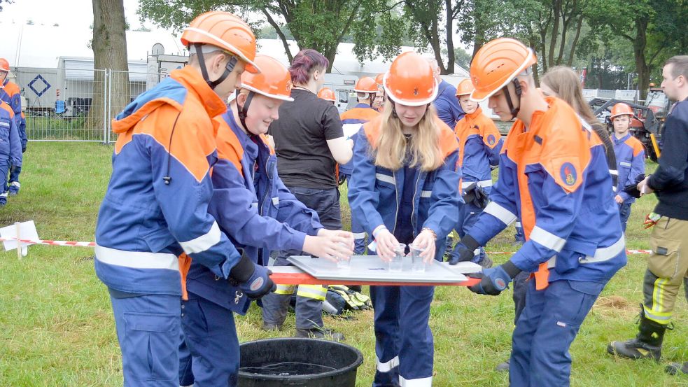 Die Jugendfeuerwehr Uplengen-Mitte beim „Wassertragen“. Bei diesem Spiel brauchen die Jugendlichen eine ruhige Hand. Foto: Weers
