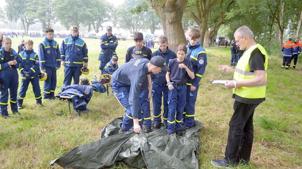 Der Nachwuchs des THW Leer zeigte Geschick: Sechs Personen stehen auf einer Plane, die nicht verlassen werden darf, während die Plane um einige Meter nach vorn geschoben werden muss. Foto: Weers