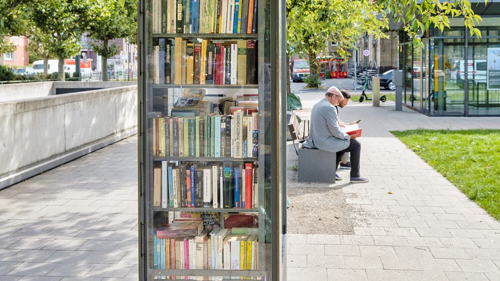 Sie bilden ein stilles Netzwerk der Bücher: öffentliche Bücherschränke, wie hier auf dem Bürgersteig der Luegallee im Düsseldorfer Stadtteil Oberkassel. Foto: imago-images/Kolvenbach