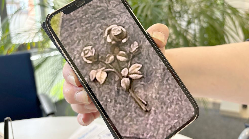 Auf ihrem Handy zeigt die Fehntjerin ein Bild von den Bronze-Rosen.