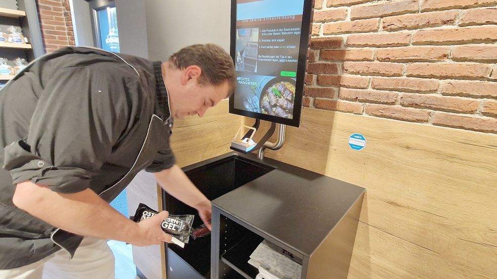 Markus Leggedör zeigt, wie man die Waren zur automatischen Abrechnung in ein Fach an der Kasse legt. Foto: Gettkowski/Archiv