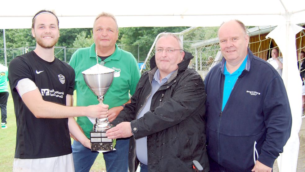 SG-Kapitän Martin Weichers bei der Siegerehrung mit Völlens 1. Vorsitzenden Thomas Weichers, Gerhard Wiechers (Germeinde Westoverledingen) und Völlens 2. Vorsitzenden Jan Uwe Kromminga.