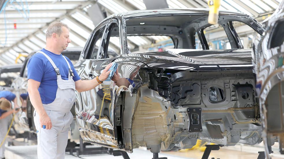 Im Wolfsburger VW-Werk wird eine Tiguan-Karosserie poliert. Der Einbruch beim Verkauf von E-Autos setzt dem Konzern zu. Foto: IMAGO IMAGES / Regios 24