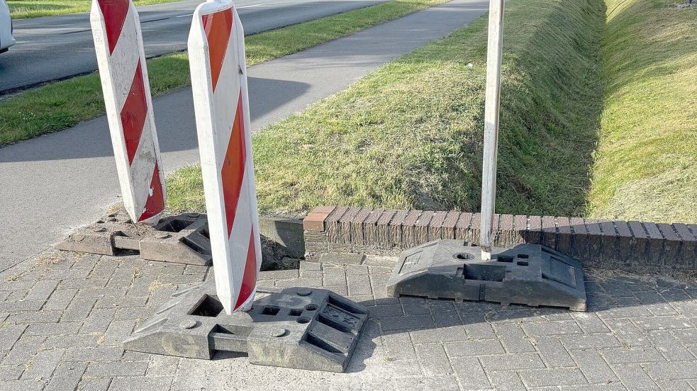 Die Gemeinde hat drei Warnbaken aufgestellt. Sie sollen verhindern, dass Fußgänger oder Radfahrer, zum Beispiel bei einem Ausweichmanöver, zu nah an die Stelle der Auffahrt heranfahren können. Foto: Ammermann