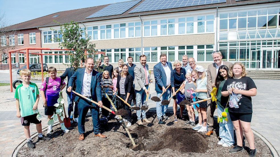 Ein Bäumchen auf dem mit EU-Geld neu gestalteten Schulhof der IGS im ammerländischen Augustfehn pflanzten Lehrkräfte und Schüler mit Regionalministerin Wiebke Osigus (8. von rechts), die die IGS auf ihrer Sommertour besuchte. Foto: Niedersächsisches Ministerium für Regionalentwicklung