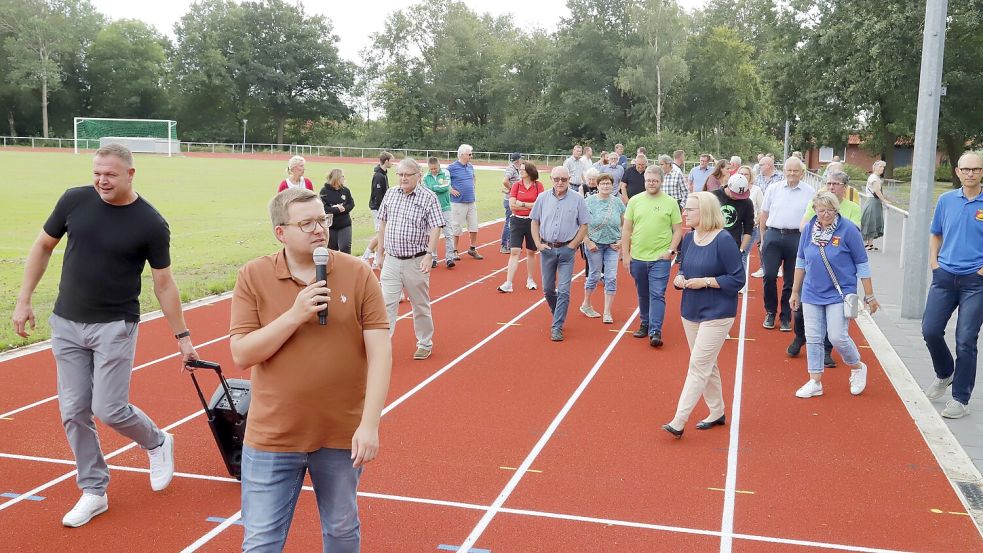Auf der neuen Rundlaufbahn informierte Bürgermeister Nils Anhuth (links) die Gäste bei der Eröffnung über die neuen Sportanlagen. Foto: Passmann