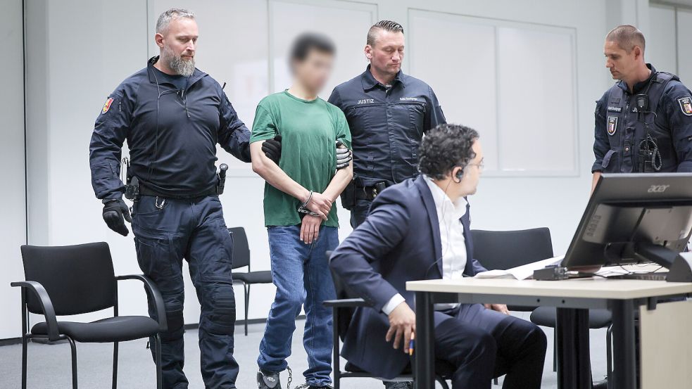 Ibrahim A. wurde von Justizbeamten in Handschellen und Fußfesseln in den Gerichtssaal gebracht. Im Prozess verurteilte das Landgericht Itzehoe den Angeklagten zu einer lebenslangen Freiheitsstrafe. Foto: Charisius/dpa