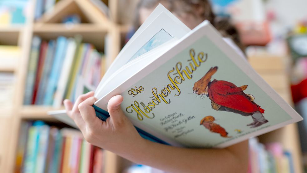 Ein Mädchen hält eine neuere Ausgabe des Kinderbuchs „Die Häschenschule“ (Thienemann-Esslinger Verlag) in ihren Händen. Der Klassiker von Albert Sixtus (1892-1960) wird in diesem Jahr 100 Jahre alt. Foto: dpa/Hendrik Schmidt