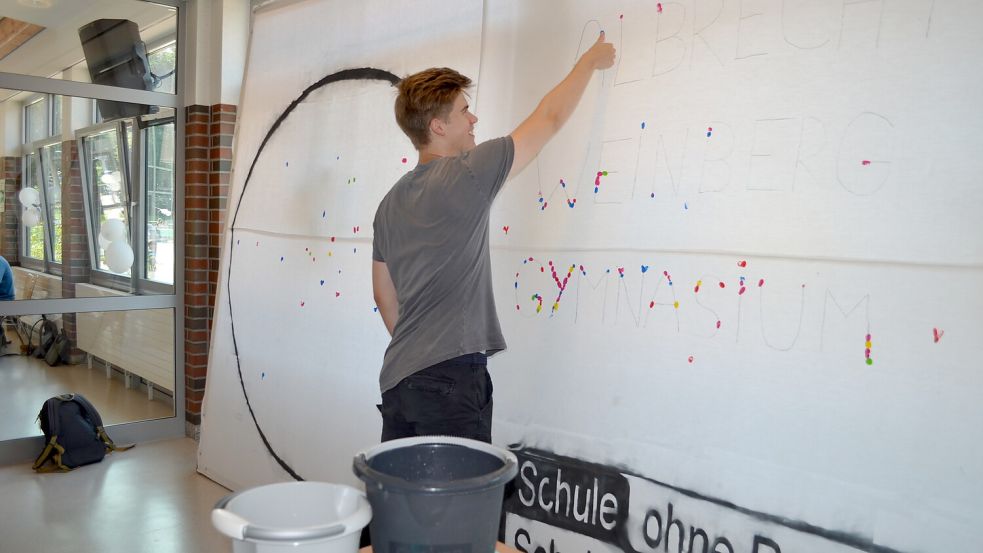 Jonathan Böhmke macht einen Fingerabdruck auf ein Plakat für das Gymnasium als Schule ohne Rassismus.