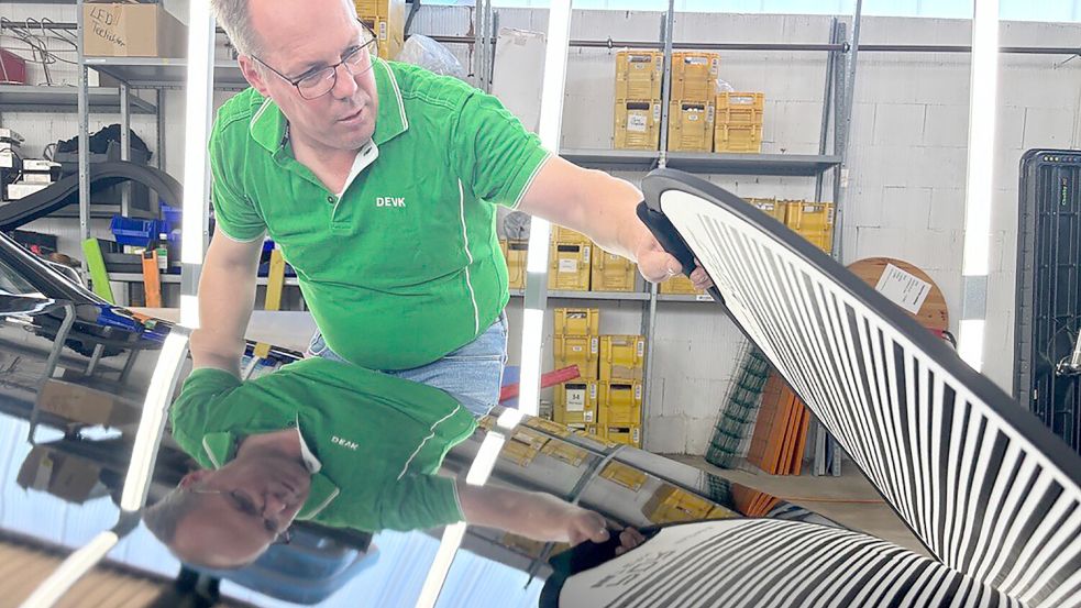 Uwe Pawelczyk von der DEVK sucht ein Auto nach Dellen ab. Foto: Kubassa